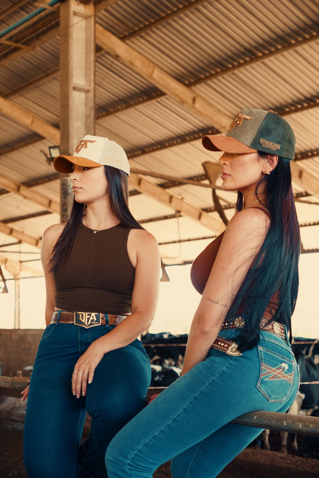 Duas mulheres usando bonés premium DFA Diferenciagro Clothing no curral da fazenda